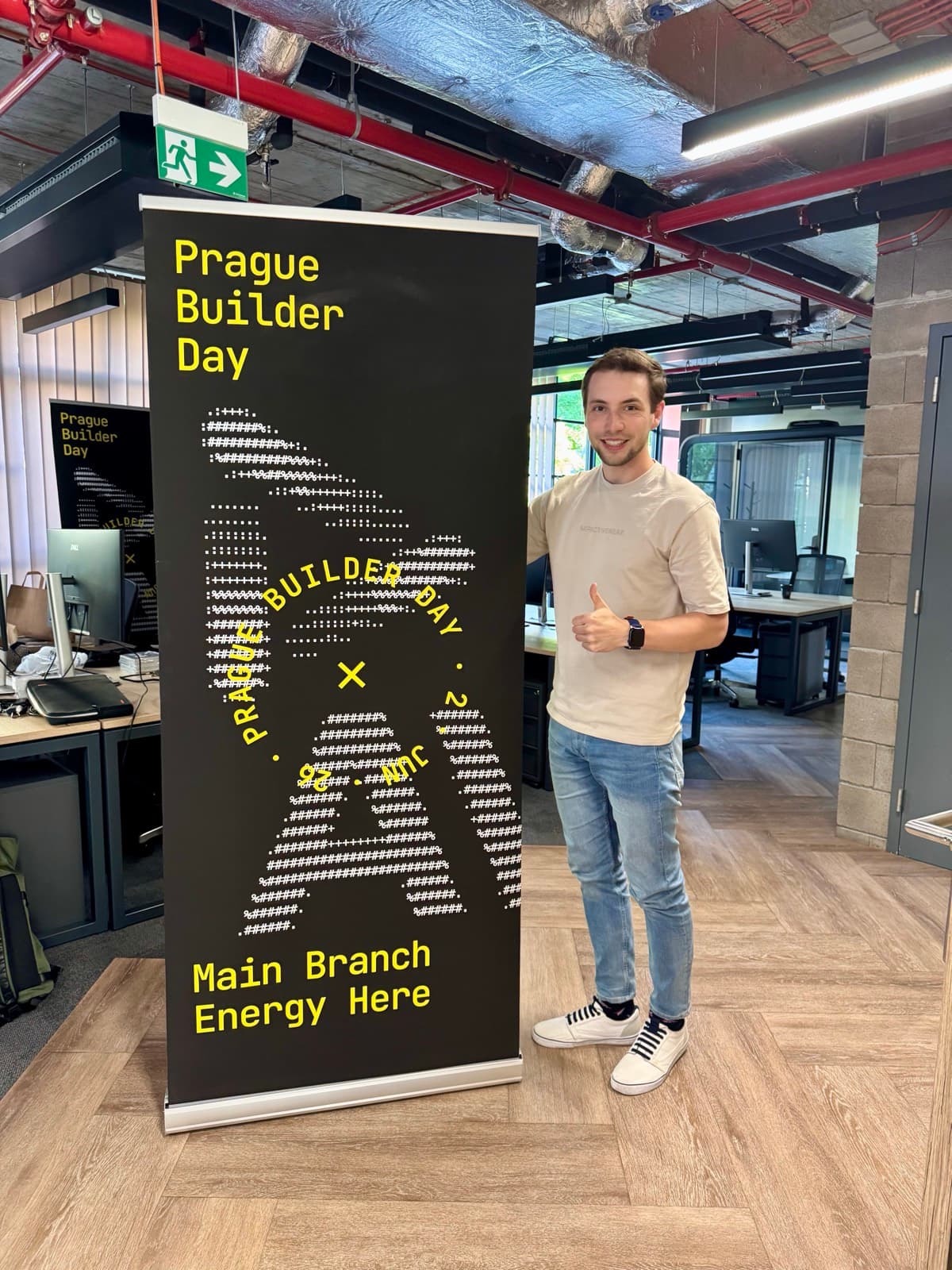 A teammate next to the Prague Builder Day banner