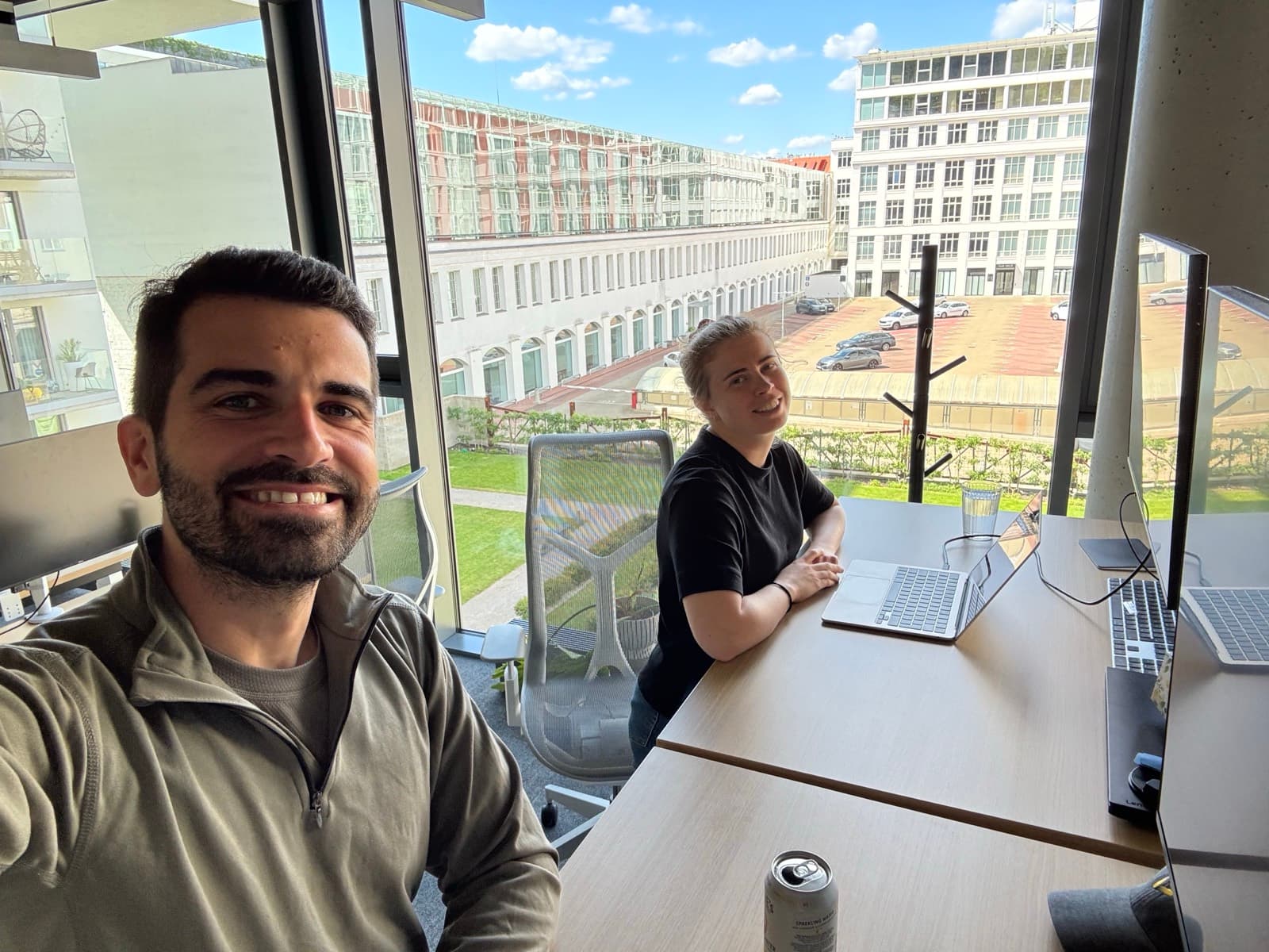 Two teammates working at a window desk