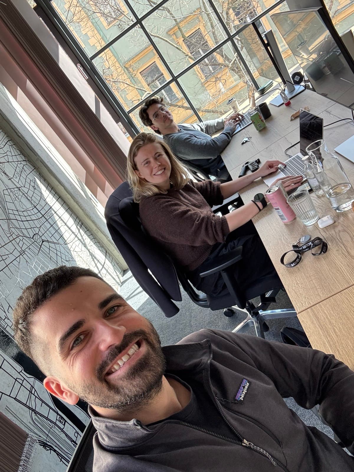 Teammates at their desks by the Prague map wall